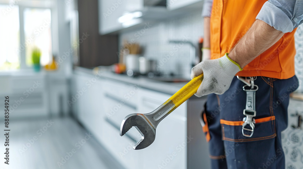 Plumber Holding a Wrench in a Modern Kitchen Plumber Holding a Wrench in a Modern Kitchen