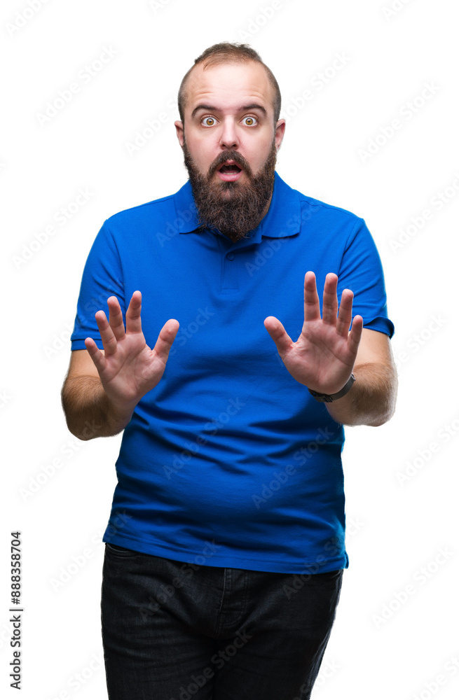 Young caucasian hipster man wearing blue shirt over isolated background afraid and terrified with fear expression stop gesture with hands, shouting in shock. Panic concept.