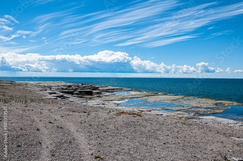 Sweeping views of layered rock formations under a dynamic sky, captured at Mingan Archipelago National Park Reserve, where land meets the endless sea. photo