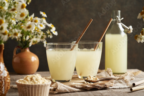 Fresh natural whey in two glass cups with recyclable paper straws photo