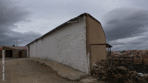 Rural construction with cloudy sky. Rural house. Rustic building. Warehouse for storage, livestock and agriculture.