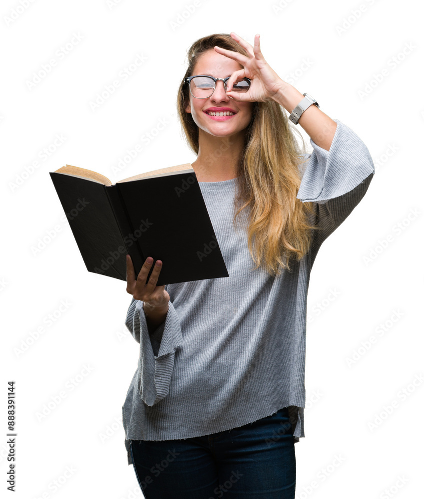 Young beautiful blonde woman reading a book over isolated background with happy face smiling doing ok sign with hand on eye looking through fingers Young beautiful blonde woman reading a book over isolated background with happy face smiling doing ok sign with hand on eye looking through fingers
