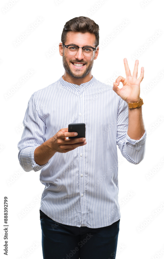 Young handsome man texting using smartphone over isolated background doing ok sign with fingers, excellent symbol Young handsome man texting using smartphone over isolated background doing ok sign with fingers, excellent symbol