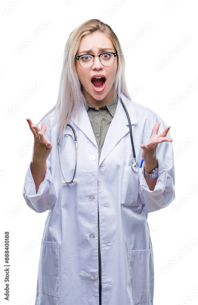 Young blonde doctor woman over isolated background crazy and mad shouting and yelling with aggressive expression and arms raised. Frustration concept. Young blonde doctor woman over isolated background crazy and mad shouting and yelling with aggressive expression and arms raised. Frustration concept.