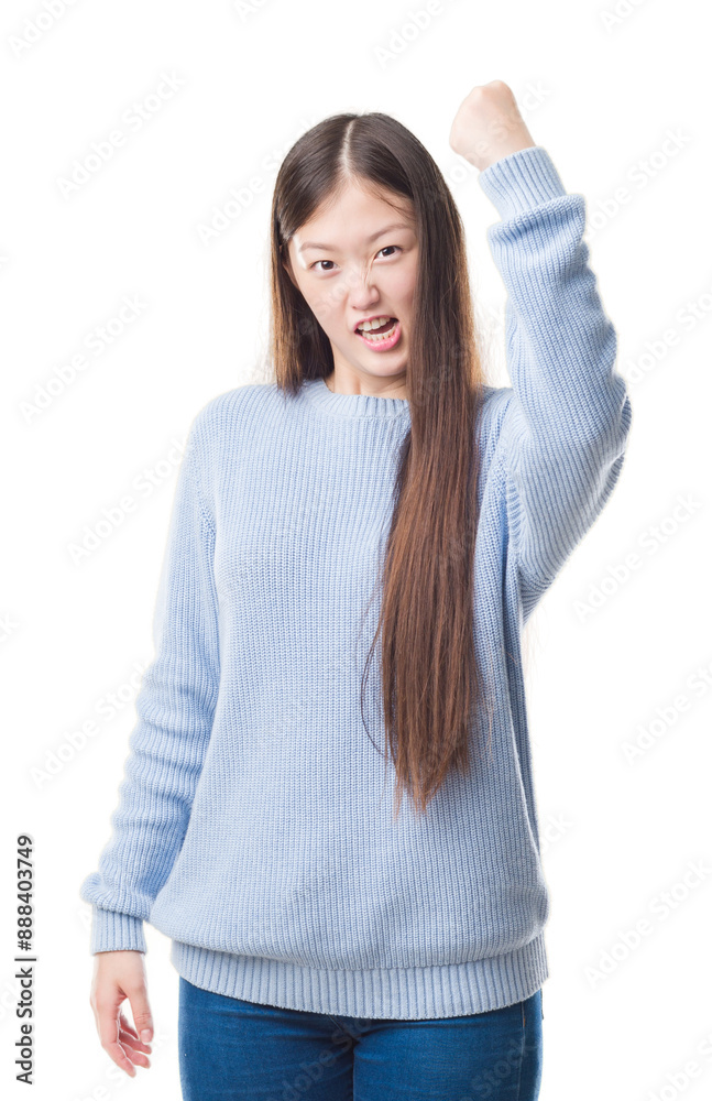Young Chinese woman over isolated background angry and mad raising fist frustrated and furious while shouting with anger. Rage and aggressive concept. Young Chinese woman over isolated background angry and mad raising fist frustrated and furious while shouting with anger. Rage and aggressive concept.