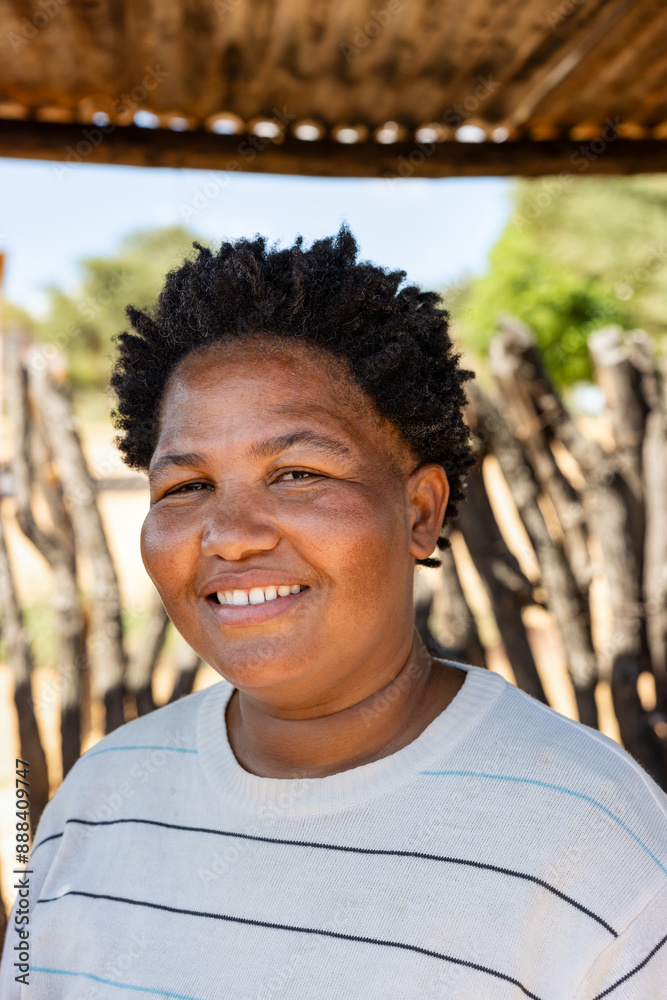 village single overweight with afro hair African woman standing in the yard in front of the wooden fence , from the outdoors kitchen village single overweight with afro hair African woman standing in the yard in front of the wooden fence , from the outdoors kitchen