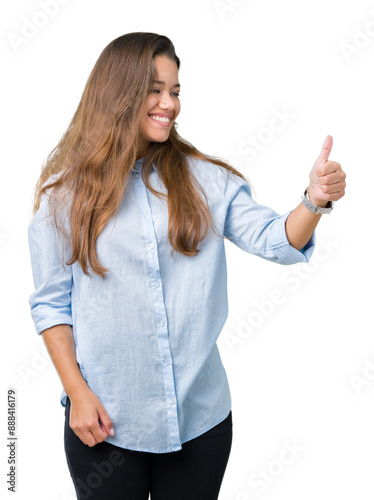 Young beautiful brunette business woman over isolated background Looking proud, smiling doing thumbs up gesture to the side