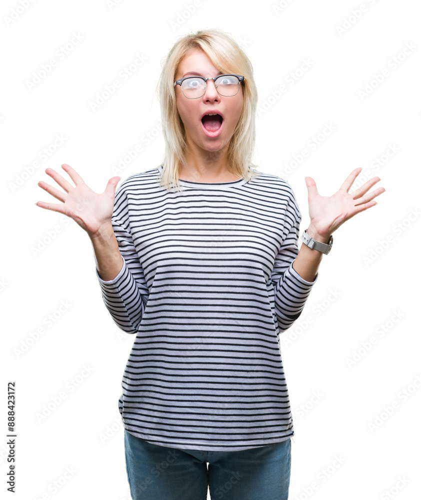 Young beautiful blonde woman wearing glasses over isolated background celebrating crazy and amazed for success with arms raised and open eyes screaming excited. Winner concept Young beautiful blonde woman wearing glasses over isolated background celebrating crazy and amazed for success with arms raised and open eyes screaming excited. Winner concept