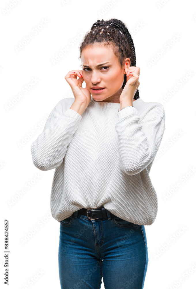 Young braided hair african american girl wearing winter sweater over isolated background covering ears with fingers with annoyed expression for the noise of loud music. Deaf concept.