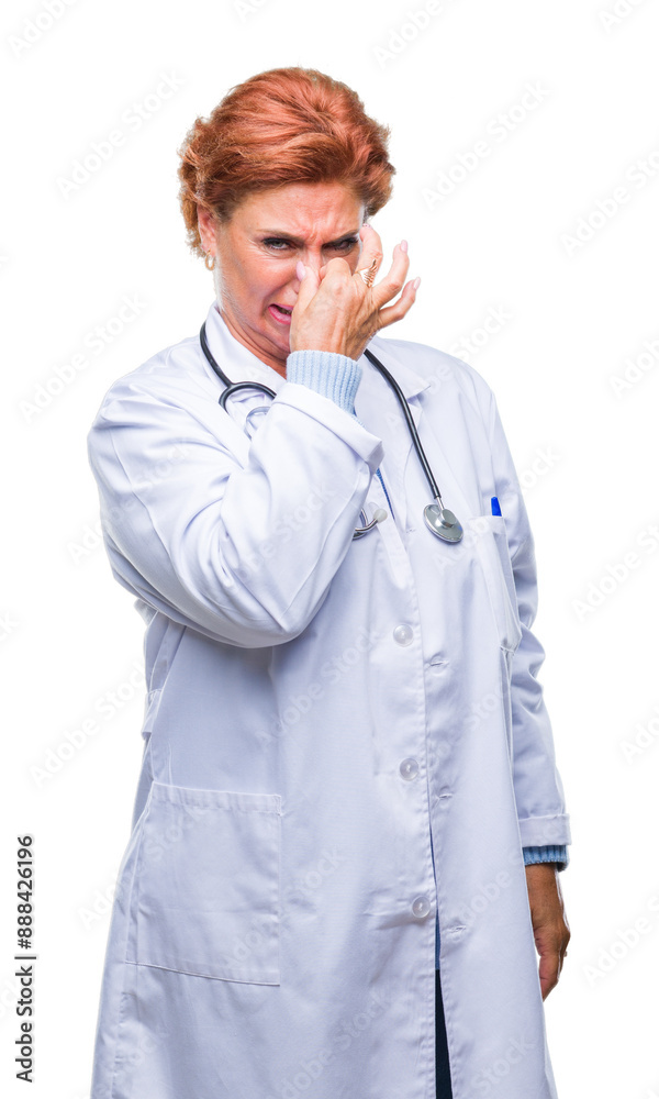 Senior caucasian doctor woman wearing medical uniform over isolated background smelling something stinky and disgusting, intolerable smell, holding breath with fingers on nose. Bad smells concept.