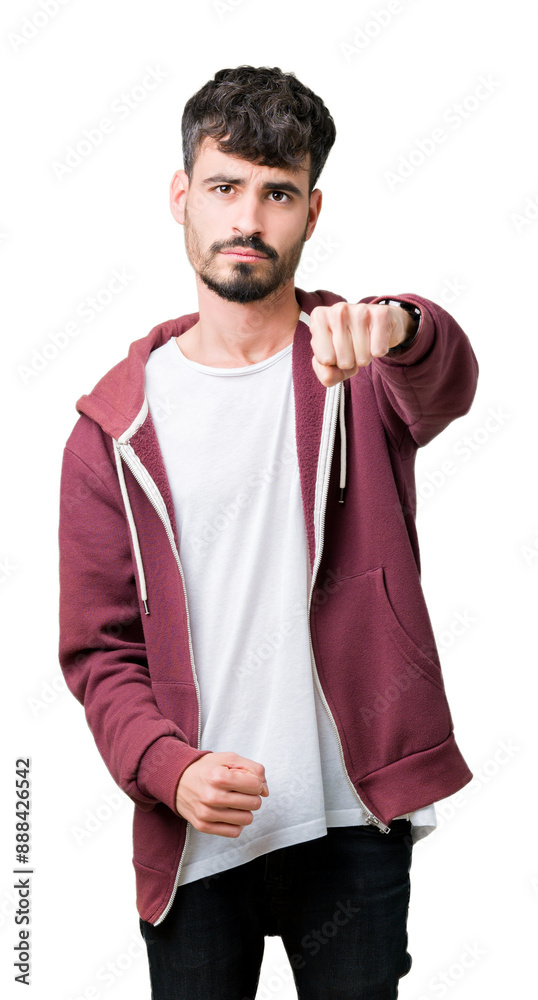 Young handsome man over isolated background Punching fist to fight, aggressive and angry attack, threat and violence