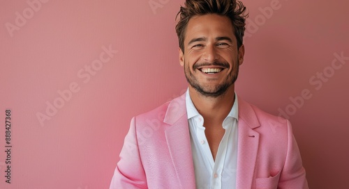 Portrait of a Smiling Man Wearing a Pink Blazer Against a Pink Wall