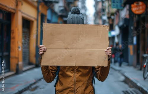Person Holding Cardboard Sign in City Street