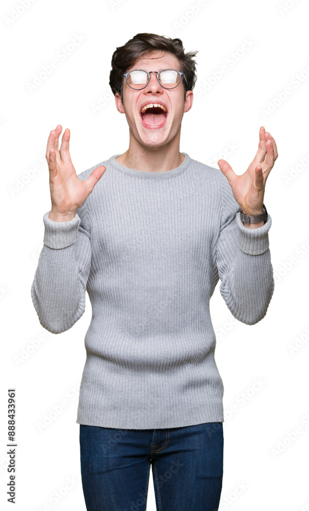 Young handsome man wearing glasses over isolated background celebrating mad and crazy for success with arms raised and closed eyes screaming excited. Winner concept Young handsome man wearing glasses over isolated background celebrating mad and crazy for success with arms raised and closed eyes screaming excited. Winner concept