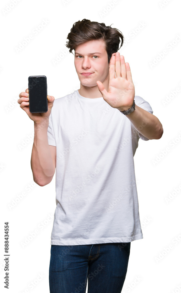 Young man showing smartphone screen over isolated background with open hand doing stop sign with serious and confident expression, defense gesture Young man showing smartphone screen over isolated background with open hand doing stop sign with serious and confident expression, defense gesture