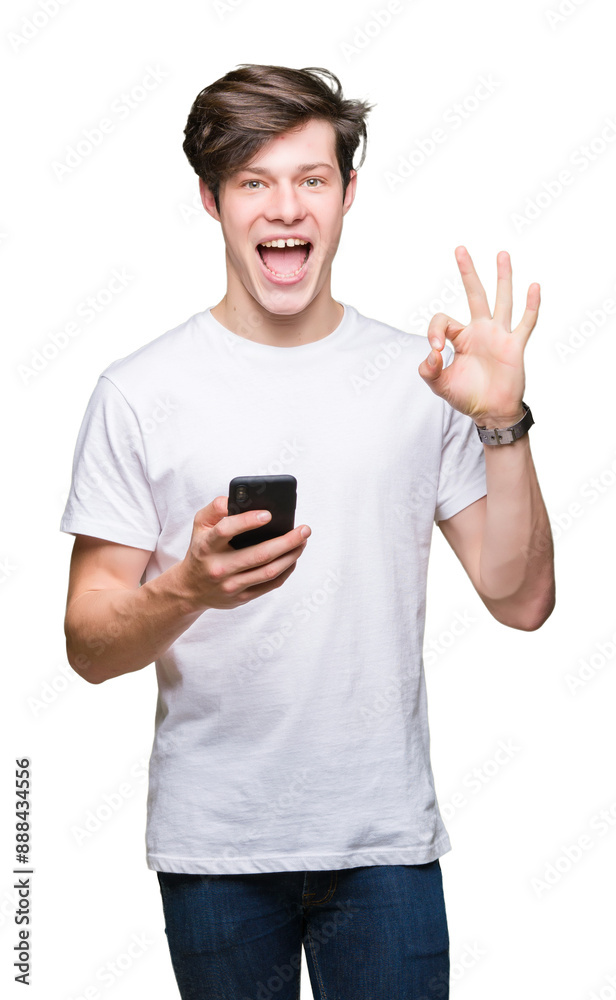 Young man using smartphone over isolated background doing ok sign with fingers, excellent symbol Young man using smartphone over isolated background doing ok sign with fingers, excellent symbol