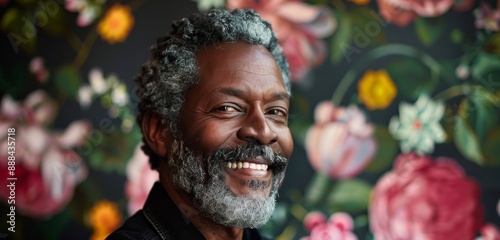 Portrait of a Smiling Man With Grey Hair Against a Floral Background