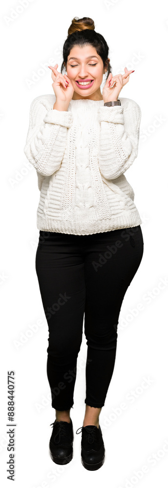 Obraz premium Young beautiful woman wearing winter sweater smiling crossing fingers with hope and eyes closed. Luck and superstitious concept.