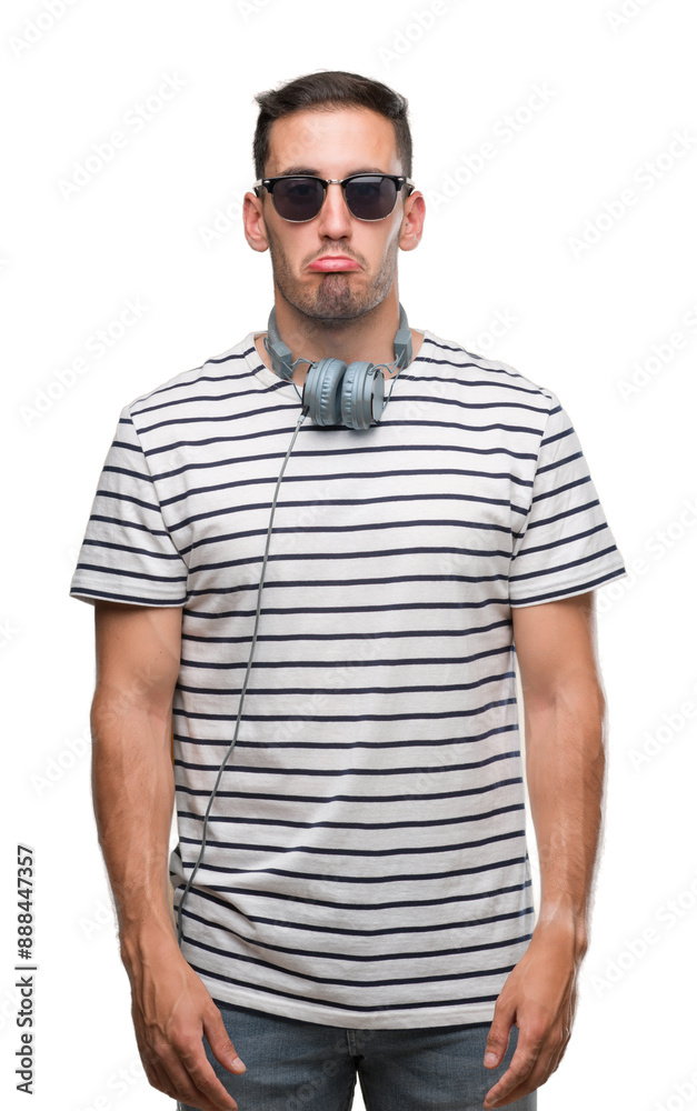 Handsome young man wearing headphones depressed and worry for distress, crying angry and afraid. Sad expression. Handsome young man wearing headphones depressed and worry for distress, crying angry and afraid. Sad expression.