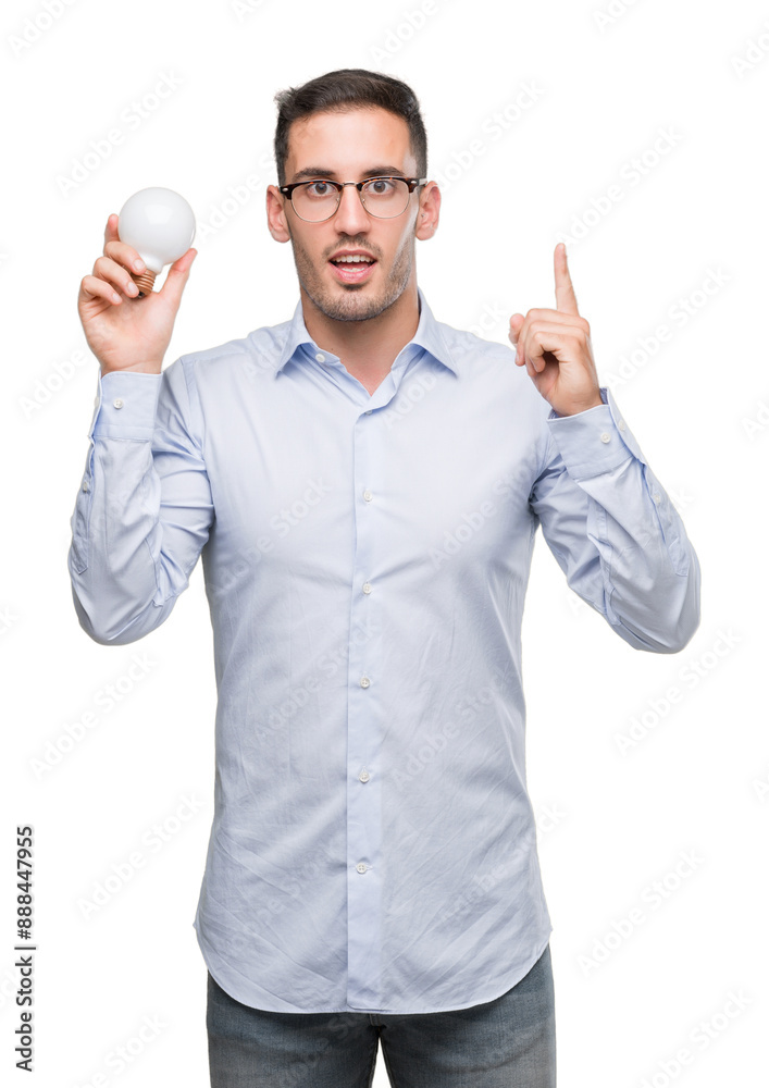 Handsome young man holding lightbulb as idea surprised with an idea or question pointing finger with happy face, number one Handsome young man holding lightbulb as idea surprised with an idea or question pointing finger with happy face, number one