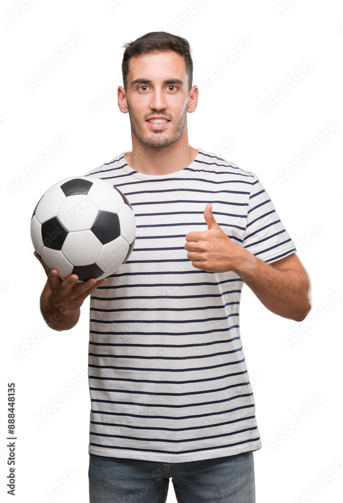 Handsome young man holding soccer football happy with big smile doing ok sign, thumb up with fingers, excellent sign Handsome young man holding soccer football happy with big smile doing ok sign, thumb up with fingers, excellent sign