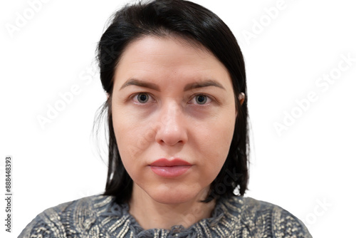 Portrait of a woman with dark hair, serious expression, and blue eyes, looking directly at the camera against a white background.