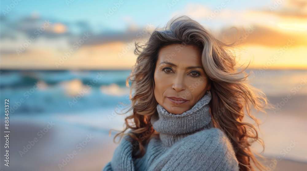 Portrait of middle age Hispanic Latina woman standing on beach with waves and ocean in background, copy space