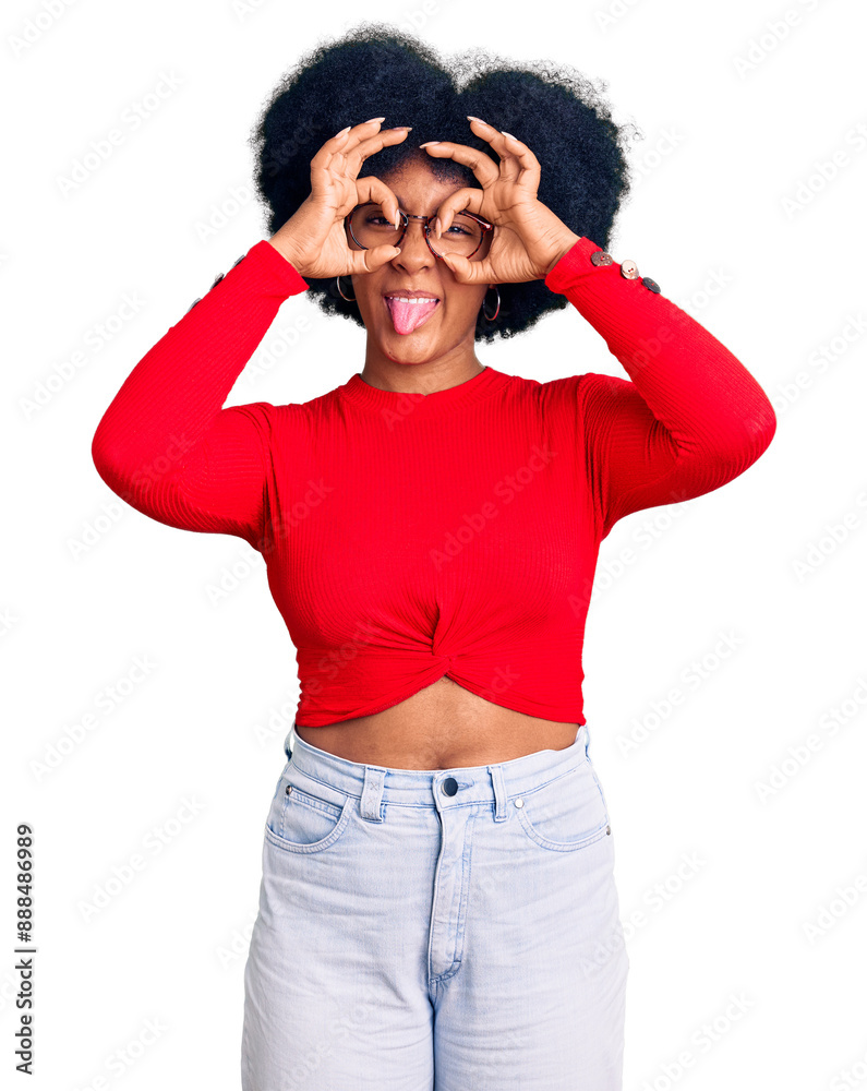 Young african american girl wearing casual clothes and glasses doing ok gesture like binoculars sticking tongue out, eyes looking through fingers. crazy expression. Young african american girl wearing casual clothes and glasses doing ok gesture like binoculars sticking tongue out, eyes looking through fingers. crazy expression.