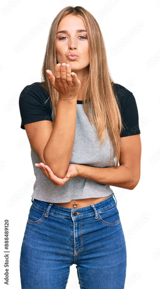 Young blonde woman wearing casual clothes looking at the camera blowing a kiss with hand on air being lovely and sexy. love expression. Young blonde woman wearing casual clothes looking at the camera blowing a kiss with hand on air being lovely and sexy. love expression.