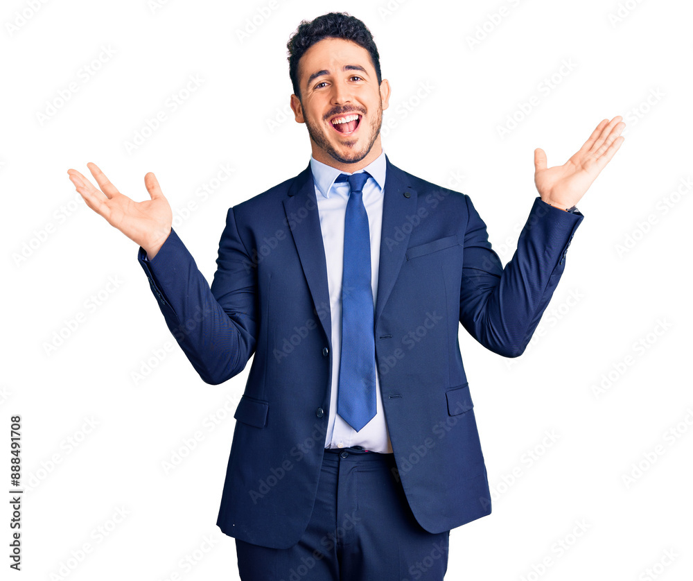 Young hispanic man wearing business clothes celebrating victory with happy smile and winner expression with raised hands Young hispanic man wearing business clothes celebrating victory with happy smile and winner expression with raised hands