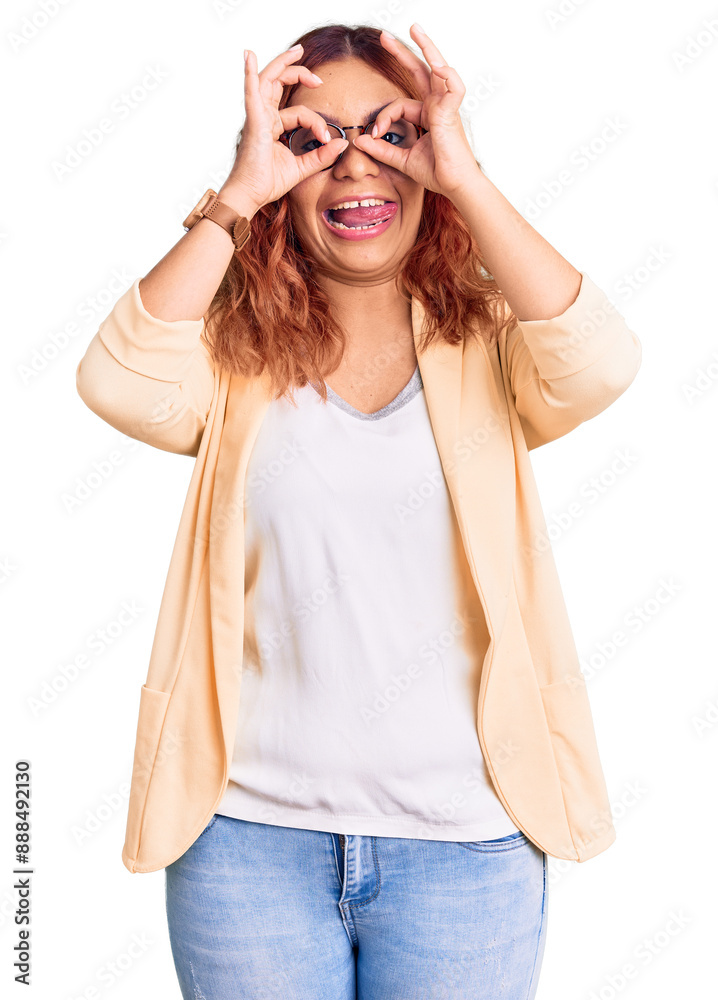 Young latin woman wearing business clothes doing ok gesture like binoculars sticking tongue out, eyes looking through fingers. crazy expression. Young latin woman wearing business clothes doing ok gesture like binoculars sticking tongue out, eyes looking through fingers. crazy expression.