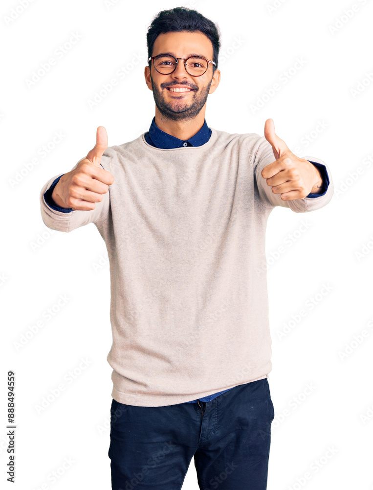 Young handsome hispanic man wearing elegant clothes and glasses approving doing positive gesture with hand, thumbs up smiling and happy for success. winner gesture. Young handsome hispanic man wearing elegant clothes and glasses approving doing positive gesture with hand, thumbs up smiling and happy for success. winner gesture.