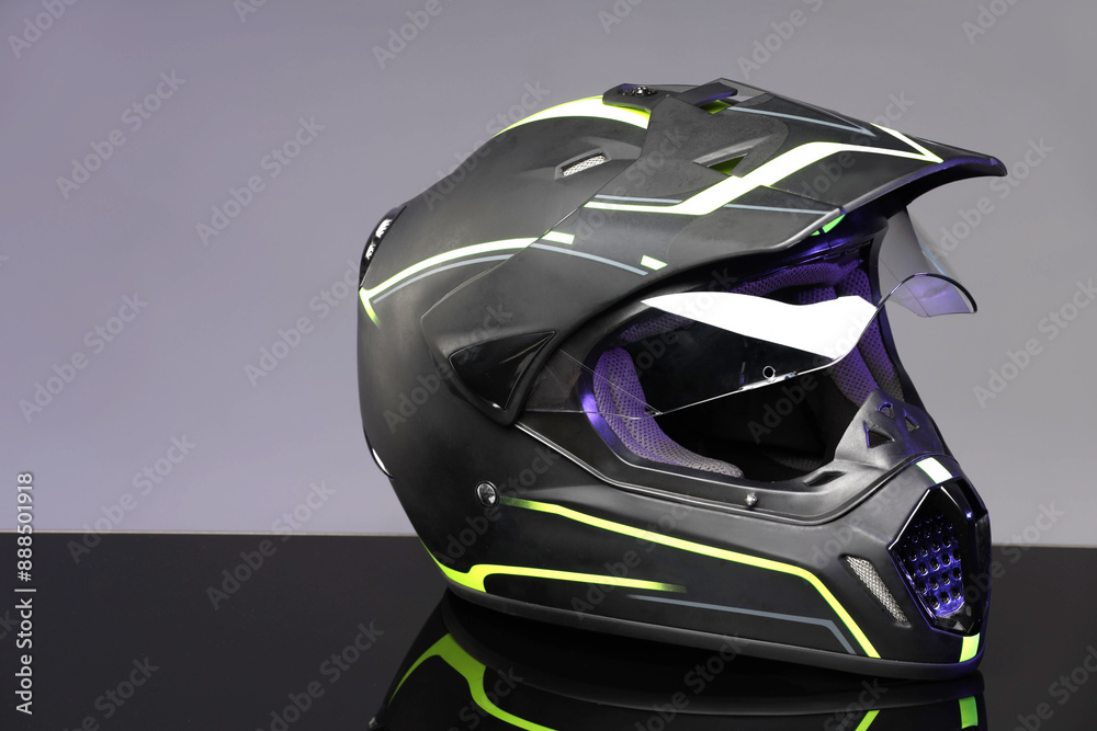 Modern motorcycle helmet with visor on mirror surface against light grey background. Space for text Modern motorcycle helmet with visor on mirror surface against light grey background. Space for text