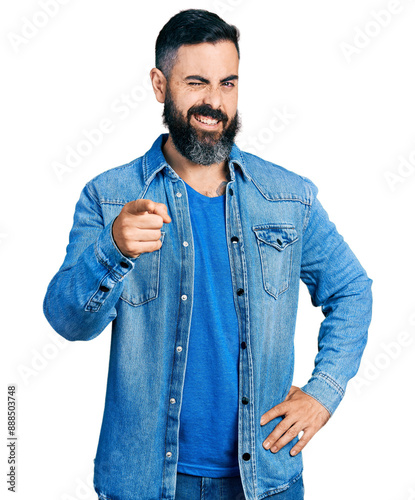 Hispanic man with beard pointing with finger to camera winking looking at the camera with sexy expression, cheerful and happy face. photo