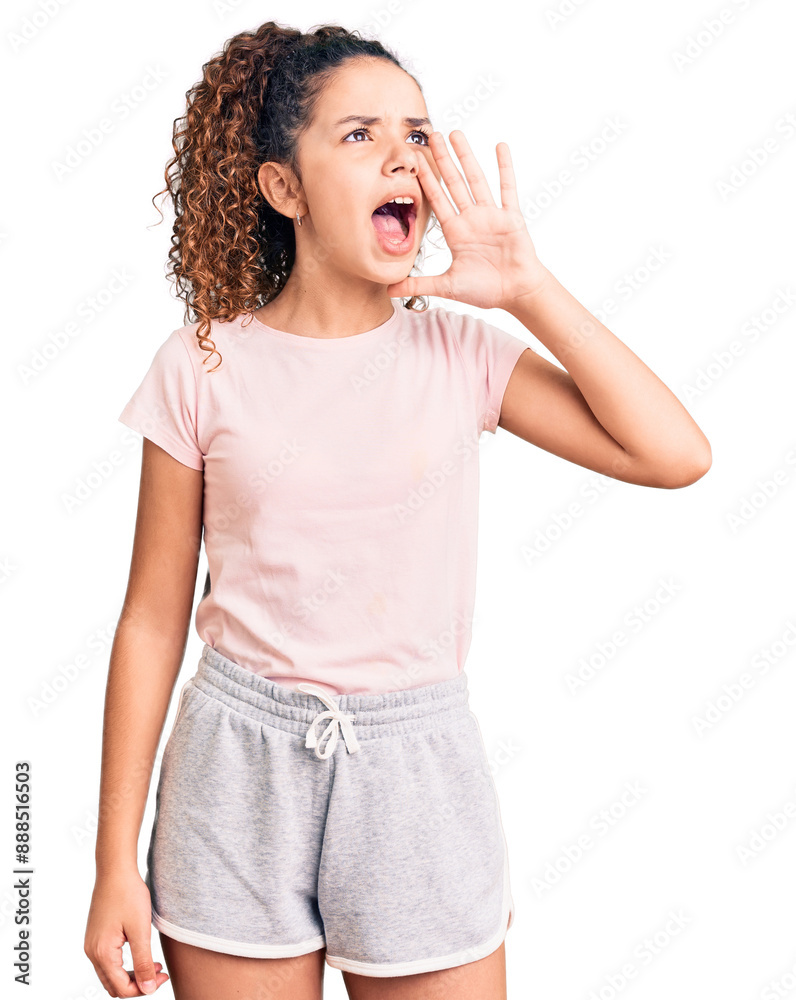 Beautiful kid girl with curly hair wearing casual clothes shouting and screaming loud to side with hand on mouth. communication concept. Beautiful kid girl with curly hair wearing casual clothes shouting and screaming loud to side with hand on mouth. communication concept.