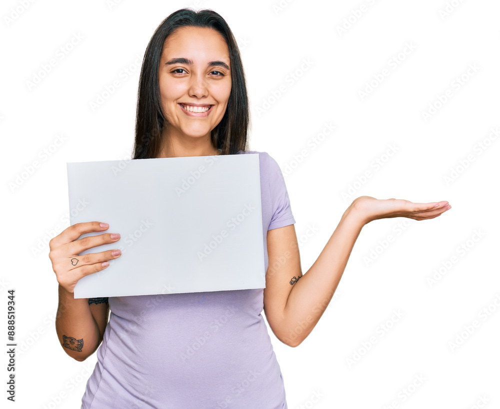 Young hispanic woman holding blank empty banner celebrating victory with happy smile and winner expression with raised hands Young hispanic woman holding blank empty banner celebrating victory with happy smile and winner expression with raised hands