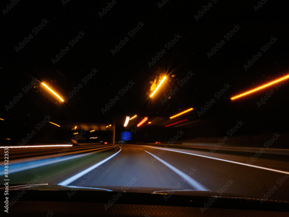 A nighttime highway scene with streaks of light from street lamps and passing vehicles creating dynamic motion, capturing the essence of speed and night driving in the Netherlands A nighttime highway scene with streaks of light from street lamps and passing vehicles creating dynamic motion, capturing the essence of speed and night driving in the Netherlands