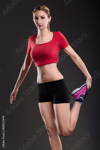 Sporty woman doing stretching exercises on dark background © Giulio_Fornasar