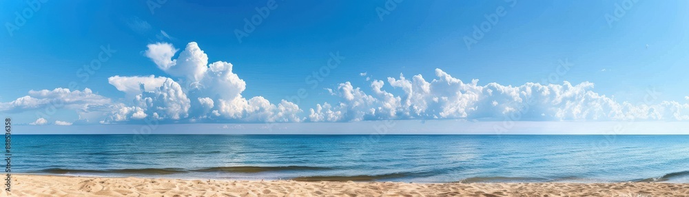 Panoramic view of a serene sandy beach with calm blue ocean and vivid clouds in the clear sky on a bright sunny day. Panoramic view of a serene sandy beach with calm blue ocean and vivid clouds in the clear sky on a bright sunny day.