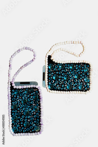 Phones electronics peeking out of elegant rhinestone glitzy bag holders or clutch purses.