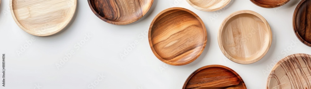 Top view of various wooden plates in different shades and patterns on a white background, offering a rustic and natural aesthetic. Top view of various wooden plates in different shades and patterns on a white background, offering a rustic and natural aesthetic.