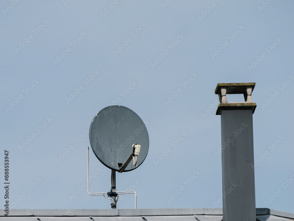 A satellite dish atop a building receives and transmits signals - digital 4k television via space satellite A satellite dish atop a building receives and transmits signals - digital 4k television via space satellite