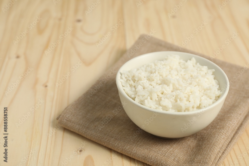 Delicious boiled rice in bowl on wooden table