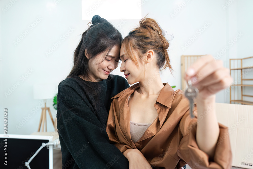 Happy LGBT Couple Embracing While Moving into New Home, Holding Keys to Their Future Together Happy LGBT Couple Embracing While Moving into New Home, Holding Keys to Their Future Together