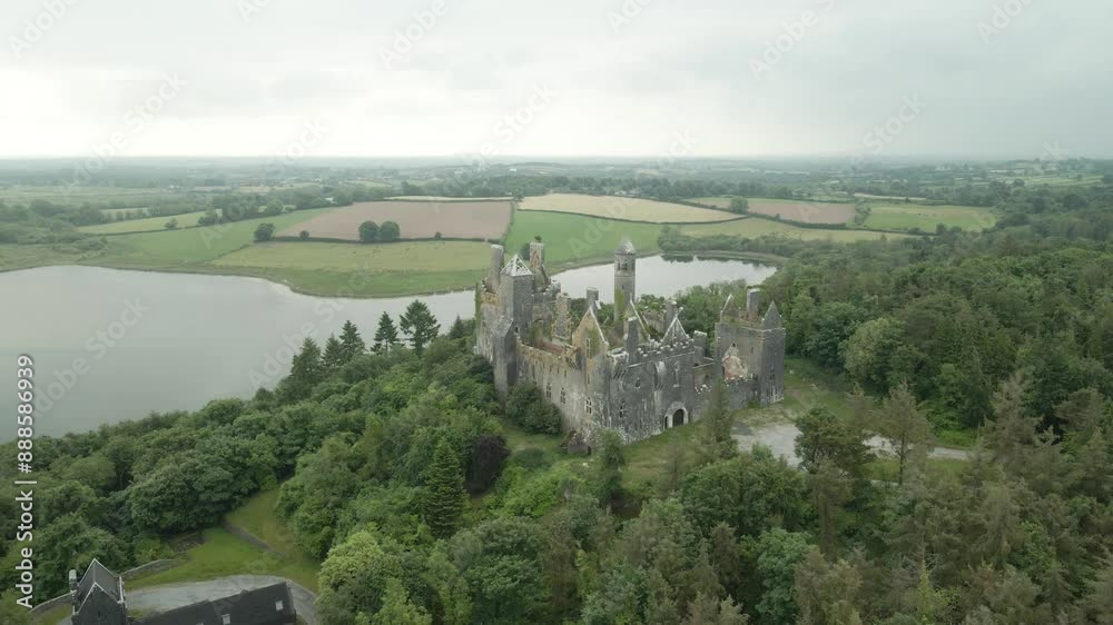 Dromore Castle aerial view, surrounded by lush greenery and a serene lake in County Limerick Ireland Dromore Castle aerial view, surrounded by lush greenery and a serene lake in County Limerick Ireland