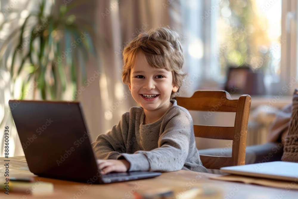 Happy boy sitting at table using laptop for online class childhood communication education learning Happy boy sitting at table using laptop for online class childhood communication education learning