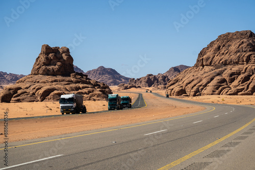 Tabuk, Saudi Arabia: Trucks driving on the stunning red desert road near Tabuk in northwestern part of Saudi Arabia in the middle east