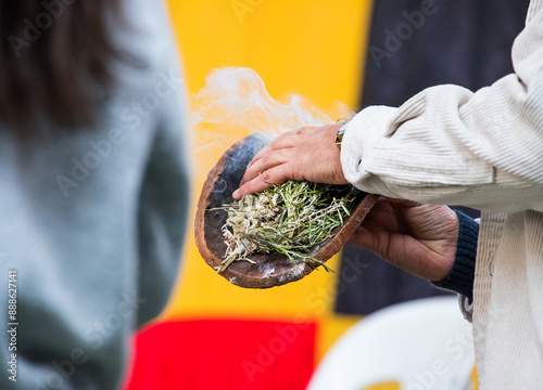 Australian Aboriginal Ceremony, man hand with green branches and flame, start a fire for a ritual rite, South Australia