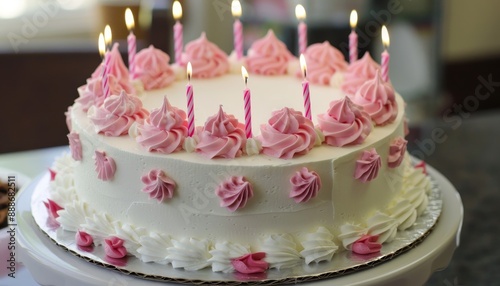 Pink drip icing and birthday candles with space for writing on the side on a birthday cake