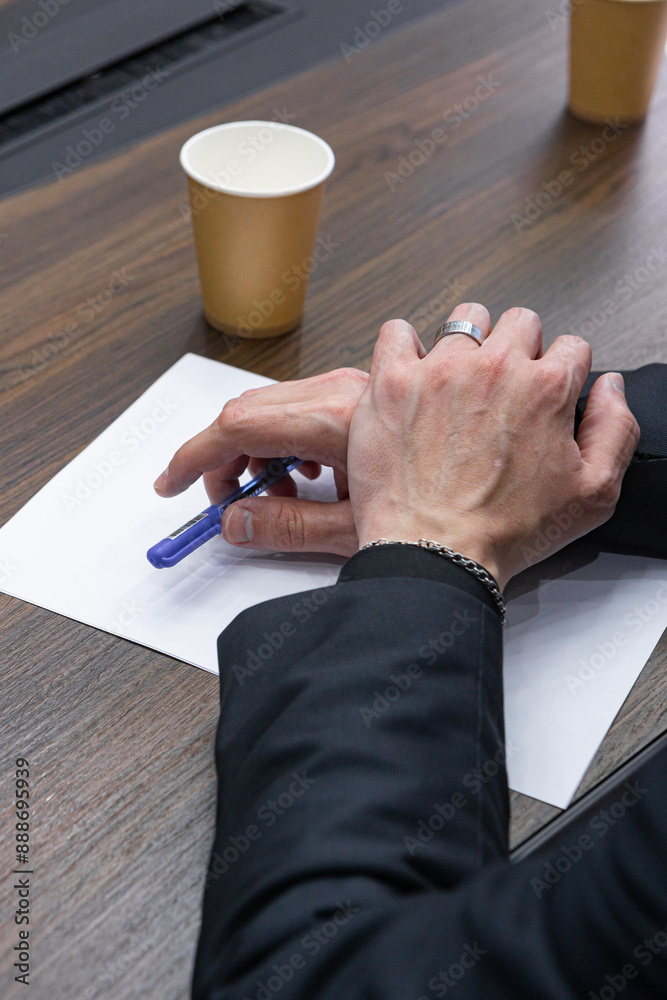 Close-up of a businessman's hands with a pen in his hands. Close-up of a businessman's hands with a pen in his hands.